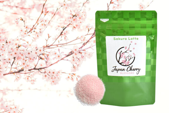 A bag of Sakura Latte with a pile of pink powder and cherry blossoms in the background, showcasing a Japanese cherry blossom theme.