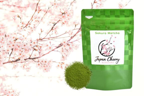 A packet of Sakura Matcha green tea powder is shown with cherry blossoms and a small pile of the powder itself.