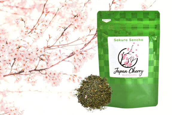 A vibrant image showcasing Sakura Sencha tea, featuring a green bag with a label, a pile of tea leaves, and a beautiful cherry blossom background.
